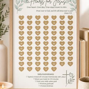 May include: A framed print titled 75 Hearts for Jesus featuring a grid of 75 numbered gold hearts. The text includes One heart. One day. One step closer to Him. Draw near to God, and He will draw near to you. James 4:8 and Daily Commitments.