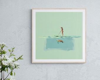 May include: Square framed art print featuring a person paddleboarding above a sea turtle. The artwork has a light green and blue color palette, with a wooden frame. The person is wearing a swimsuit and holding a paddle.