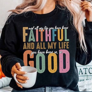 May include: Black sweatshirt with a colorful graphic print that reads "and all my life you have been FAITHFUL AND ALL MY LIFE you have been so, so GOOD".