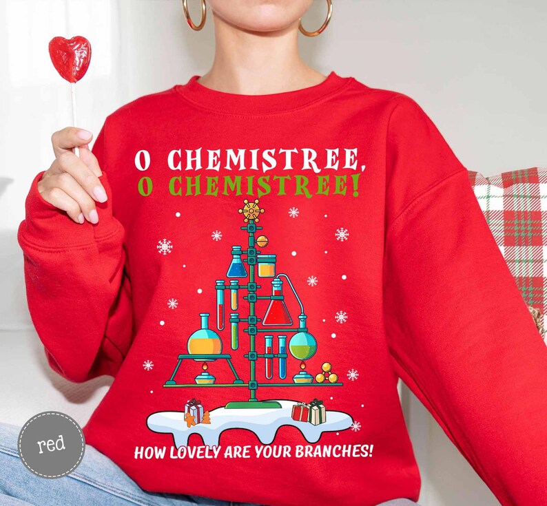 May include: A red sweatshirt with a science-themed Christmas tree design. The tree is made of lab equipment, with the text "O Chemistree, O Chemistree! How lovely are your branches!" printed on the front.