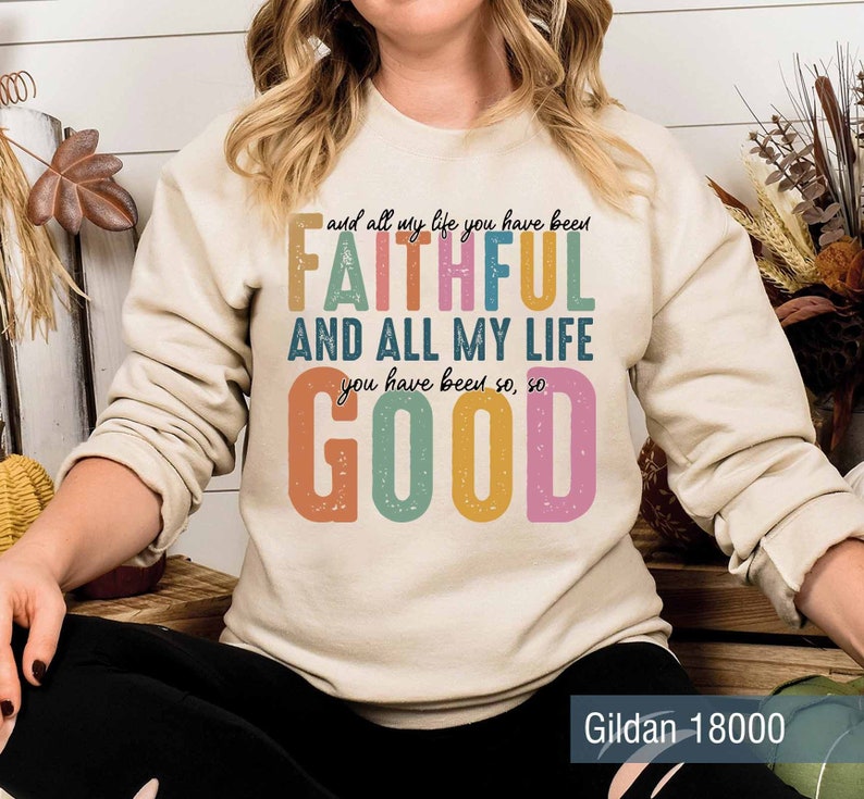 May include: A beige sweatshirt with a colorful graphic print that reads "and all my life you have been FAITHFUL AND ALL MY LIFE you have been so, so GOOD". The text is in a retro style font with a distressed look. The sweatshirt is a Gildan 18000.