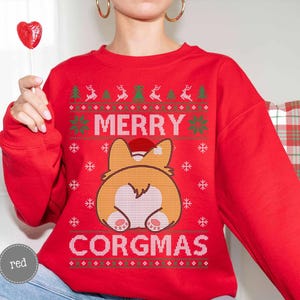 May include: Red Christmas jumper with a white 'Merry Corgmas' design and a cartoon corgi wearing a Santa hat.