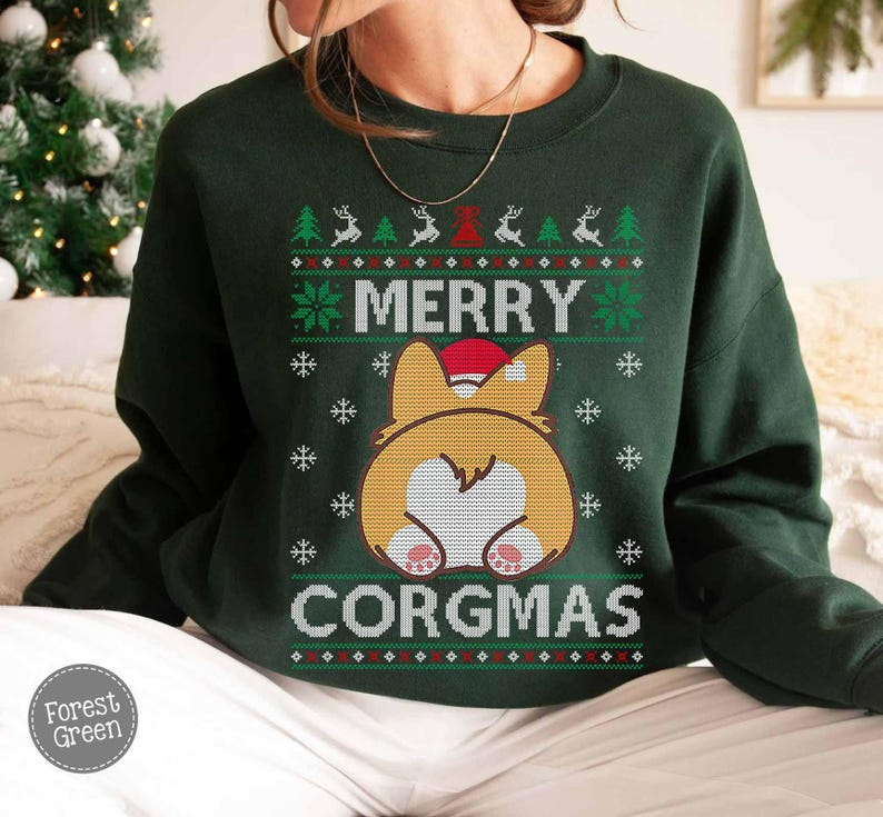 May include: Green Christmas jumper with a white and red pattern. The jumper features a cartoon image of a corgi wearing a Santa hat with the text "Merry Corgmas".