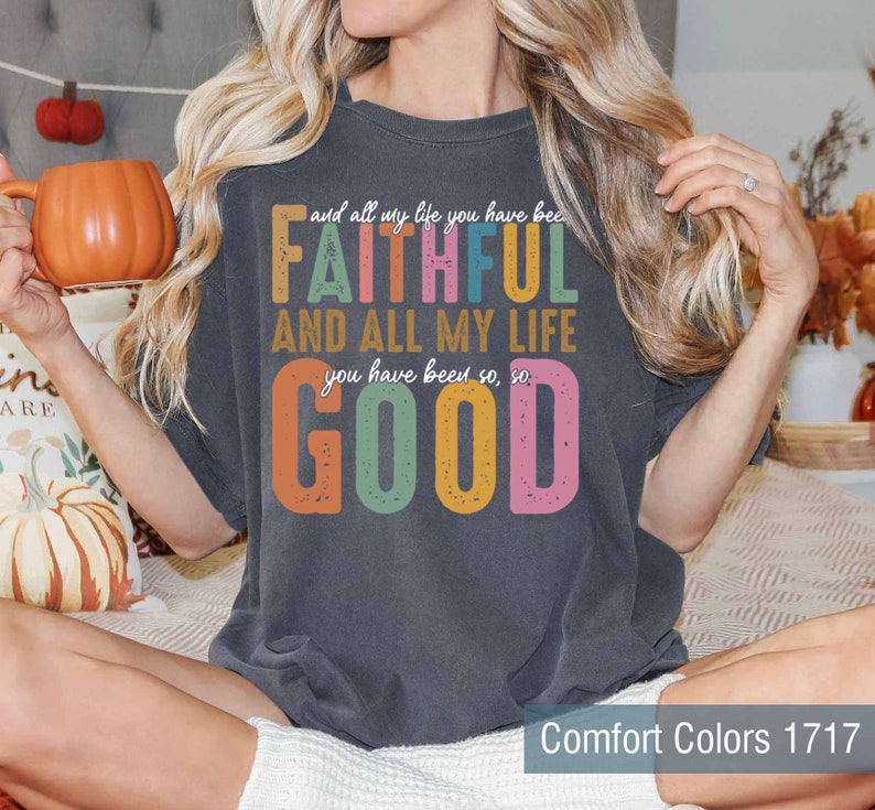 May include: A dark gray t-shirt with a colorful graphic that reads "and all my life you have been FAITHFUL AND ALL MY LIFE you have been so, so GOOD". The text is in a retro style with a distressed look.