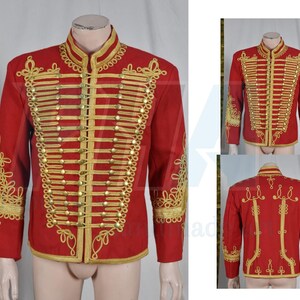 May include: A red military-style jacket with gold embroidery and trim. The jacket features a high collar, rows of gold buttons, and ornate gold detailing on the sleeves and back. The jacket is displayed on a mannequin.