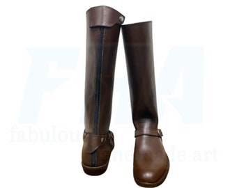 May include: A pair of brown leather riding boots with a zipper on the back and a buckle strap on the front.