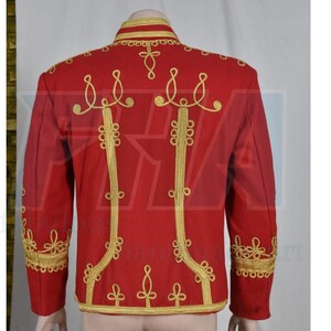 May include: A red jacket with gold embroidery. The jacket features ornate gold detailing along the collar, shoulders, and down the front. The back of the jacket is visible, showcasing the intricate gold patterns. The jacket has long sleeves and a high collar.