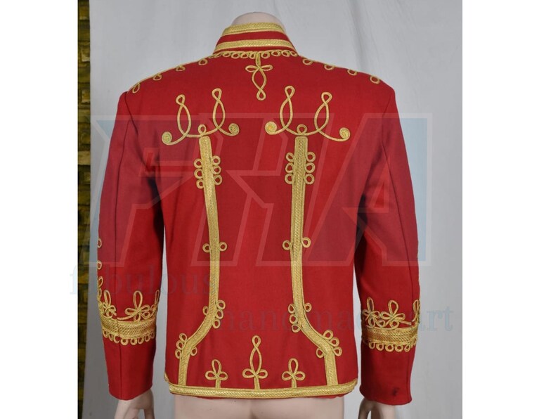 May include: A red jacket with gold embroidery. The jacket features ornate gold detailing along the collar, shoulders, and down the front. The back of the jacket is visible, showcasing the intricate gold patterns. The jacket has long sleeves and a high collar.