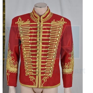 May include: A red military-style jacket with gold-colored trim and buttons. The jacket features a high collar and decorative gold embroidery on the sleeves. The front has multiple rows of gold braid and buttons, creating a formal appearance.