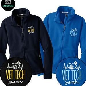May include: Two fleece jackets, one navy blue and one royal blue, with a full zip and a high collar. Each jacket features an embroidered design that reads "VET TECH Sarah" with a paw print and heartbeat graphic.
