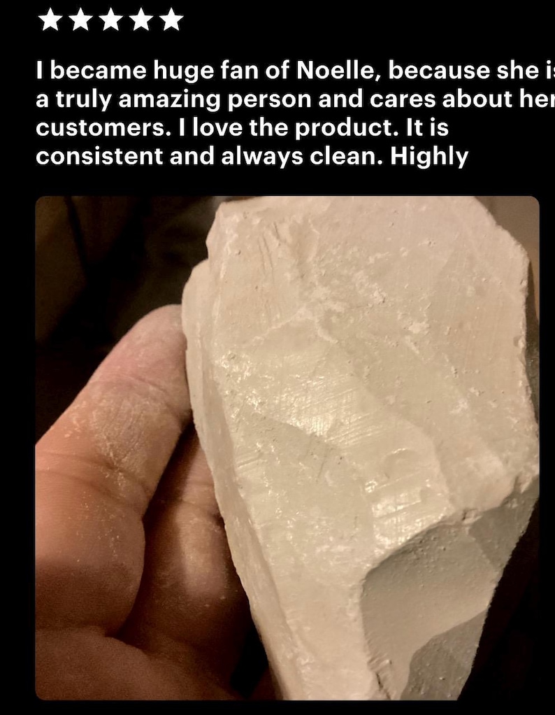 May include: A large, irregular chunk of off-white, chalky mineral with a matte, textured surface. The object features sharp, angular edges and a powdery appearance, showing visible striations and natural fractures across its solid, opaque form.