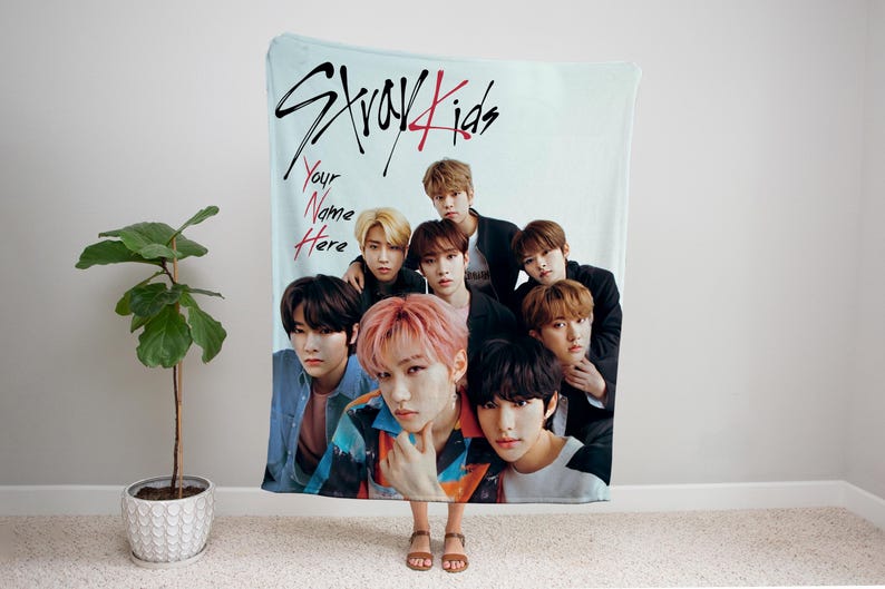 Puede incluir: Una manta de franela azul y blanca con un grupo de ocho j&oacute;venes. La manta tiene las palabras "Stray Kids" escritas en negro y rojo. El texto "Your Name Here" est&aacute; escrito en rojo.