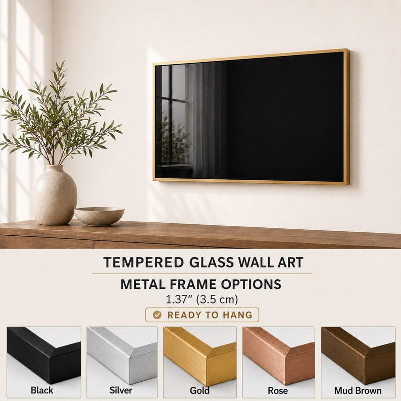 a wall art display with a black framed picture hanging on a wall. The wall art is mounted on a wooden shelf, and there is a vase with a plant on the shelf. The image also includes a selection of metal frame options available for hanging the wall art, along with a description of the frame options.