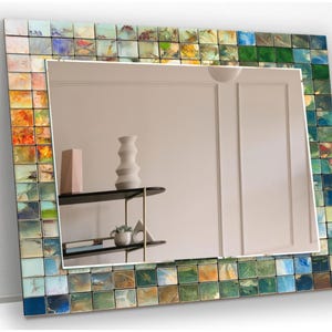 a mirror that has a vase on a shelf in front of it