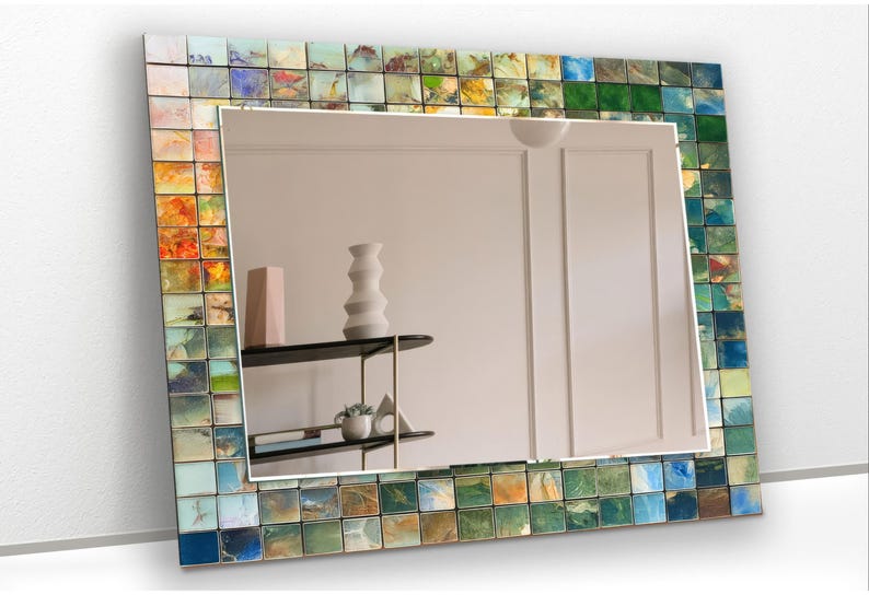 a mirror that has a vase on a shelf in front of it