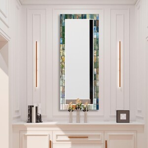 a bathroom vanity with a mirror and a vase with flowers
