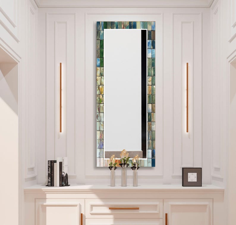 a bathroom vanity with a mirror and a vase with flowers