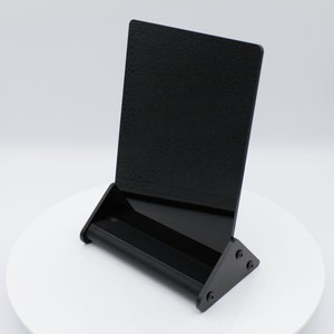 May include: Black acrylic menu holder with a built-in stand and a slot for business cards or flyers.