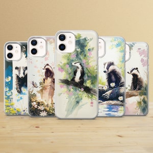 Könnte beinhalten: Fünf transparente Handyhüllen mit Aquarell-Illustrationen von Dachsen in verschiedenen Posen. Die Dachse sind von Blumen und Blättern umgeben. Die Hüllen sind alle für das iPhone.