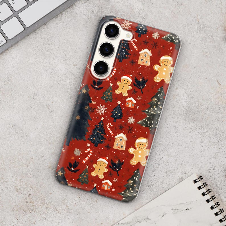 May include: A red phone case with a Christmas theme. The case features gingerbread men, candy canes, and Christmas trees. The case has a clear back and a white camera cutout.