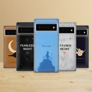 Peut inclure: Plusieurs coques de téléphone avec des motifs variés. L'une est bleu clair avec une silhouette et le texte "Stage Lights". D'autres présentent des motifs célestes et en forme de cœur avec des textes comme "Fearless Night" et "Untamed Heart".