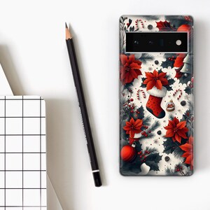 May include: A white phone case with a Christmas-themed design. The design features red poinsettia flowers, candy canes, holly, and a red stocking with a white cuff.