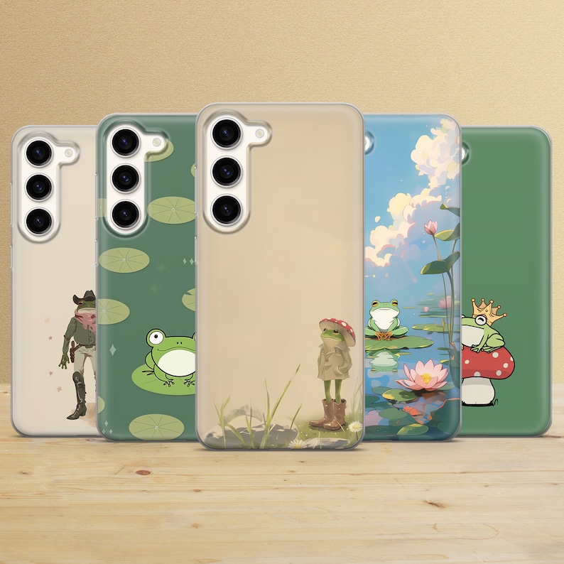 K&ouml;nnte beinhalten: Vier verschiedene Handyh&uuml;llen mit Froschdesigns. Die H&uuml;llen sind transparent und zeigen das Objektiv der Handykamera. Die Designs beinhalten einen Frosch mit Cowboyhut, einen Frosch, der auf einem Seerosenblatt sitzt, einen Frosch mit Mantel und Hut und einen Frosch mit Krone.