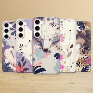May include: Four phone cases with a floral design and a wolf or fox illustration. The cases are white with pink, blue, and green flowers. The animals are white with black noses and eyes.