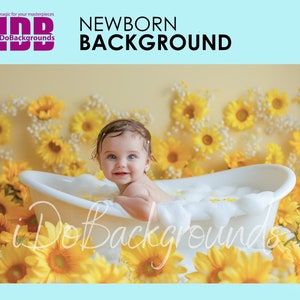 May include: A baby in a white bathtub surrounded by yellow sunflowers. The baby is smiling and looking at the camera. The bathtub is filled with white bubbles.