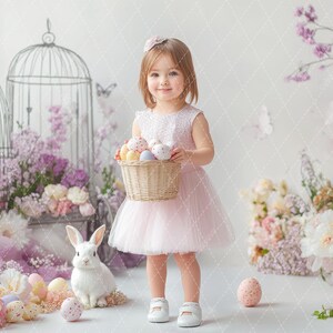 May include: A young girl in a pink tulle dress holds a basket of colorful Easter eggs. She is standing in front of a backdrop of flowers and cages.