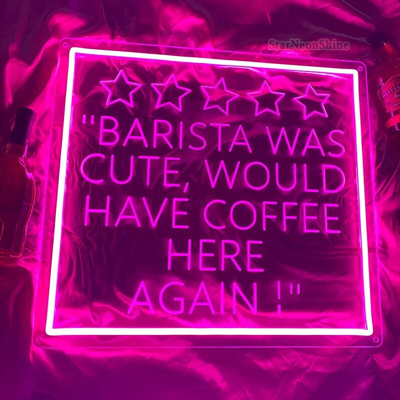 May include: Pink neon sign with white lettering that reads "BARISTA WAS CUTE, WOULD HAVE COFFEE HERE AGAIN!" with five white stars above the text.