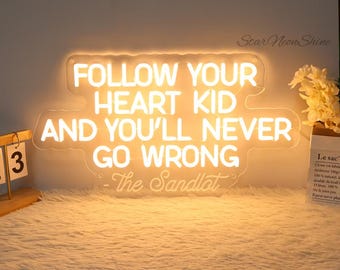 May include: White neon sign with the quote "Follow your heart kid and you'll never go wrong - The Sandlot".