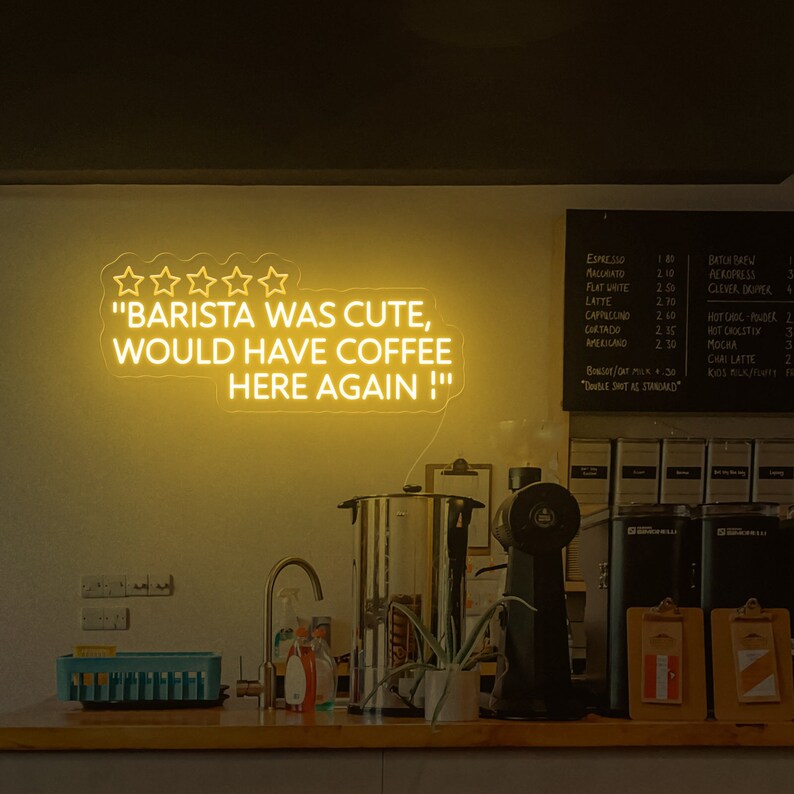May include: A neon sign with five stars and the text "BARISTA WAS CUTE, WOULD HAVE COFFEE HERE AGAIN!" in a coffee shop setting.