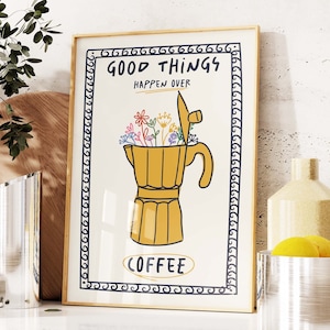 Könnte beinhalten: Ein gerahmter Druck mit weißem Hintergrund und schwarzem Rahmen. Der Druck zeigt eine gelbe Kaffeekanne mit bunten Blumen darin. Der Text "Good Things Happen Over Coffee" ist in schwarzen Buchstaben geschrieben.
