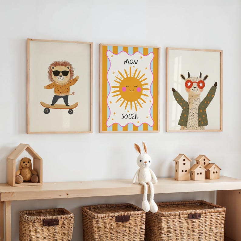 Puede incluir: Tres l&aacute;minas enmarcadas con ilustraciones de animales. Un le&oacute;n en monopat&iacute;n, un sol sonriente con el texto "MON SOLEIL" y una llama con gafas de sol. Las l&aacute;minas est&aacute;n en marcos de madera clara.