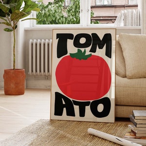 May include: A framed poster featuring a red tomato with the word "TOMATO" written in black.