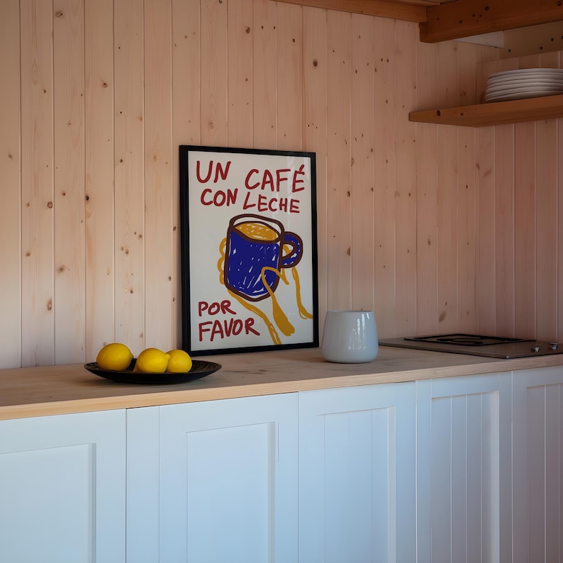 以下が含まれることがあります： 白い背景に赤い文字と黒い文字で「Un cafe con leche por favor」と書かれた、コーヒーカップの漫画イラストが描かれた額縁入りポスターです。