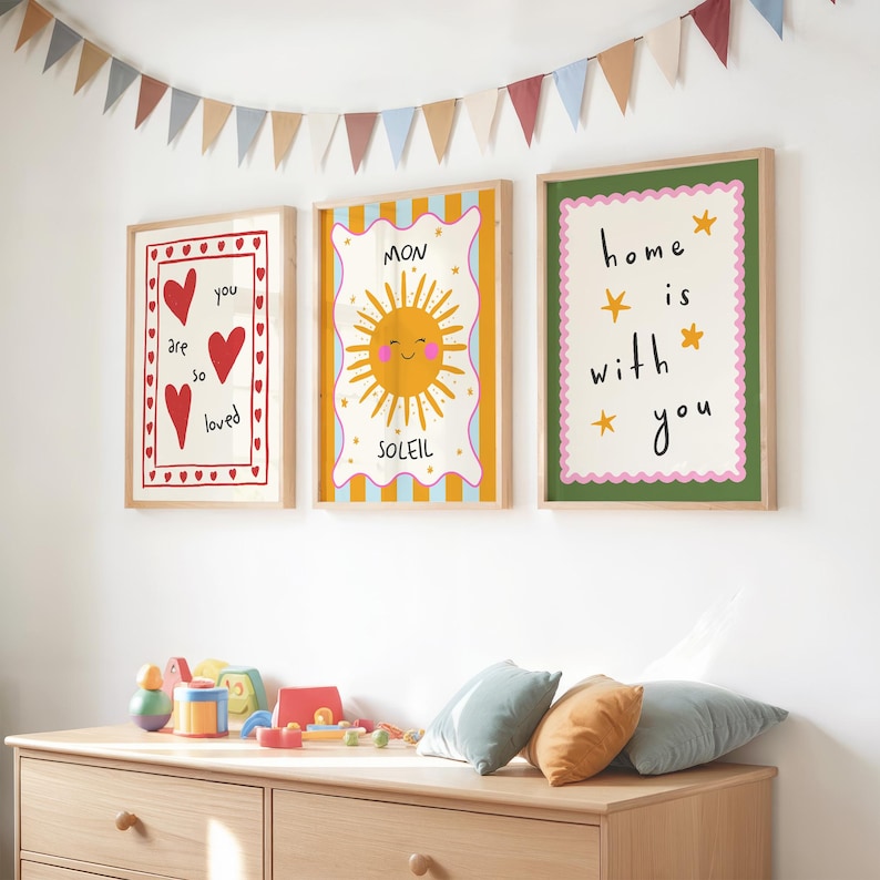 Puede incluir: Tres l&aacute;minas enmarcadas con mensajes positivos e ilustraciones. Una l&aacute;mina dice "you are so loved" con corazones rojos. Otra presenta un sol sonriente y la palabra "SOLEIL". La tercera dice "home is with you".