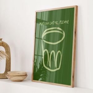 May include: A framed green and yellow illustration of a glass with the text "Matcha Latte, Please" on a green background.