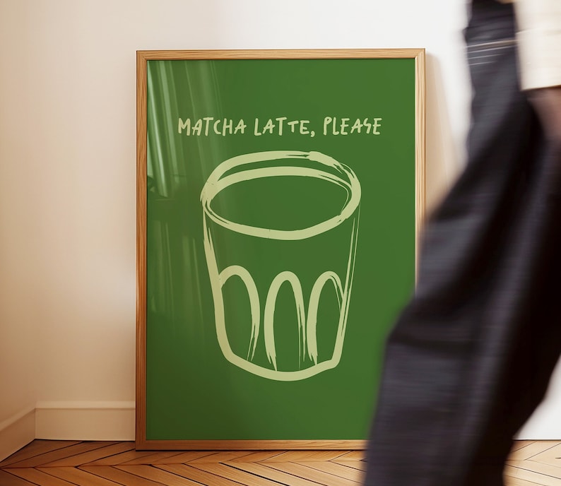 May include: A framed green poster with the text "MATCHA LATTE, PLEASE" in white. A hand-drawn illustration of a glass of matcha latte is in the center of the poster.