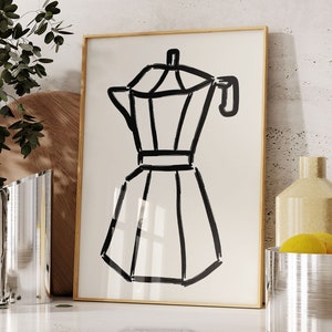 May include: A framed art print featuring a black line drawing of a stovetop espresso maker. The artwork is set against a cream-colored background and framed in a light wood. The image is a minimalist kitchen-themed illustration.