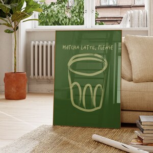 May include: A green framed poster with the text "Matcha Latte, Please" and a hand-drawn illustration of a cup of matcha latte.