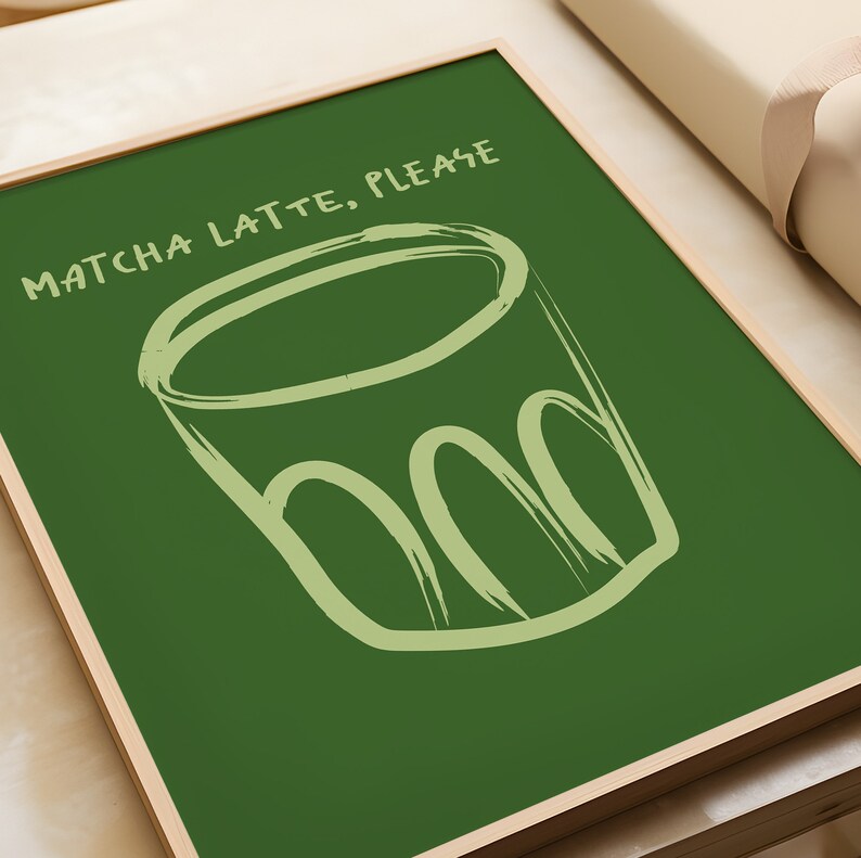 May include: A green chalkboard with a white wooden frame. The chalkboard has a hand-drawn illustration of a cup of matcha latte and the text "MATCHA LATTE, PLEASE".
