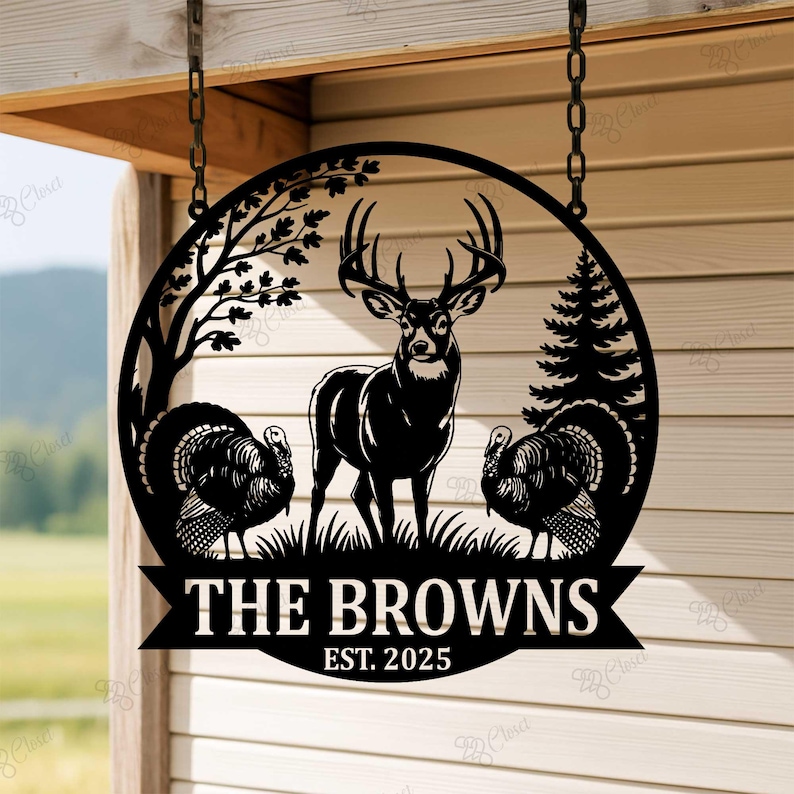 Puede incluir: Letrero de nombre familiar de metal negro con un ciervo, dos pavos, &aacute;rboles y el texto "THE BROWNS EST. 2025" en un dise&ntilde;o circular. El letrero est&aacute; colgado de una cadena.