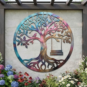 May include: A circular metal wall art piece featuring a tree with intricate branches, roots, and several small birds perched on the limbs. A swing hangs from one of the branches. The metal has a multi-colored, iridescent finish with blue, purple, and copper tones.