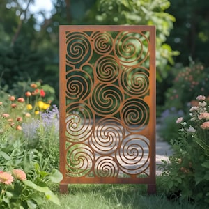 May include: A rectangular, rusty-brown metal garden screen with a repeating spiral pattern. The screen is set on a grassy lawn, with a blurred background of flowers and greenery. The decorative panel is designed for outdoor use.