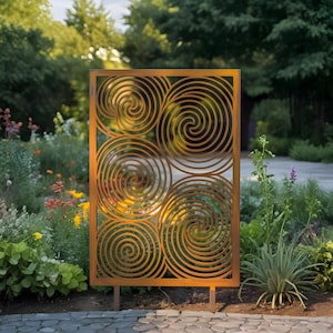May include: A weathered metal garden screen with a rectangular frame and cut-out spiral patterns. The screen is supported by metal posts and set in a garden with various plants and flowers. The screen's dimensions are approximately 120 cm x 180 cm.
