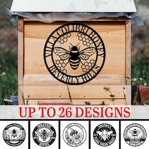 May include: A wooden beehive with a black metal sign featuring a bee and the words "Villa Colibri Honey Beverly Hills." The image includes the text "Up to 26 Designs" and several circular logo designs with bees.