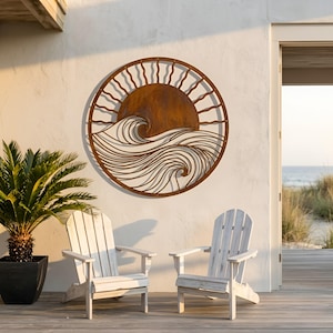 May include: A round, rusty metal wall art piece depicting a sun rising over ocean waves. The artwork is mounted on a white stucco wall, with two white Adirondack chairs on a wooden deck in front of it. A potted palm tree is to the left.