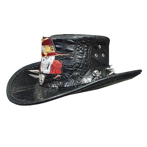 May include: A black leather cowboy hat with a skull and crossbones design. The hat has silver studs and spikes around the brim.